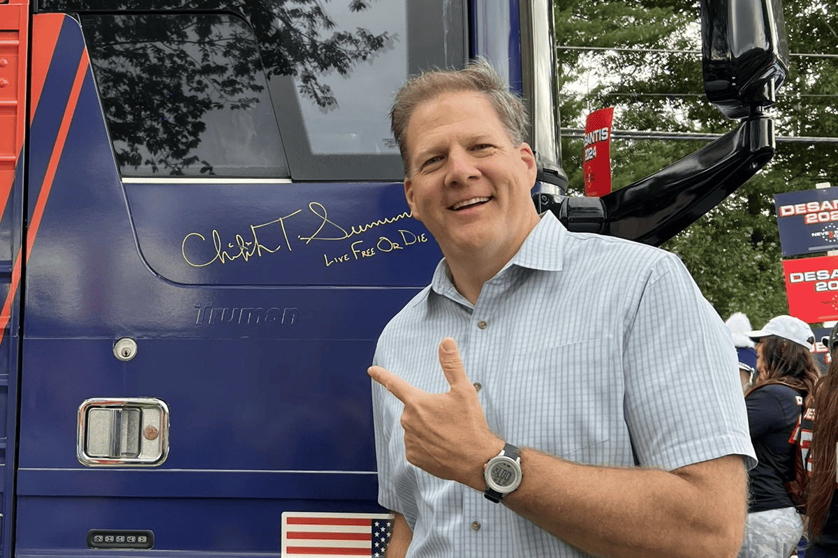 New Hampshire Gov. Chris Sununu signs Never Back Down bus, a super PAC supporting Gov. Ron DeSantis for president in 2024. (Photo/Never Back Down, X)